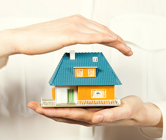 hand hovering small family house, home insurance concept